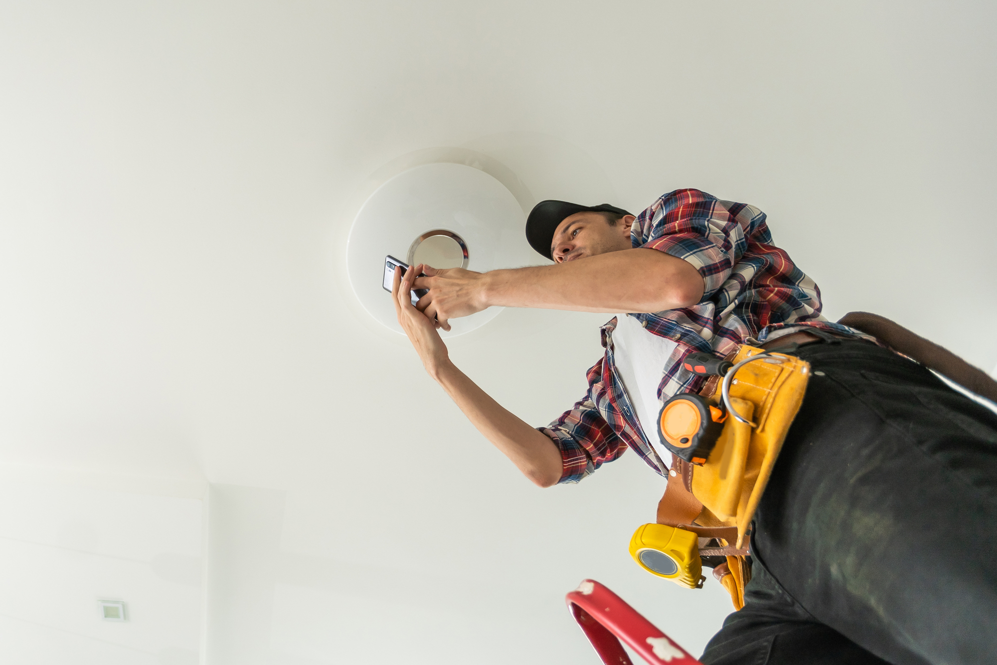 electrician installing led light bulbs in ceiling lamp